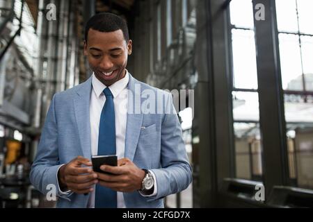 Trendy black businessman using phone Stock Photo
