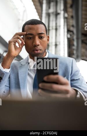 man using smartphone sitting at table Stock Photo