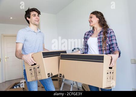 Young couple holding carton boxes in new apartment taking and smiling Stock Photo
