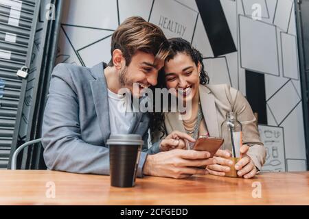 Couple using phone at a bar Stock Photo