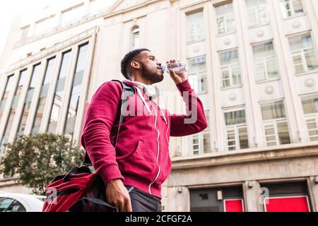 Sporty young man drinking water in the street Stock Photo
