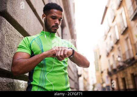 Young man checking his watch in the street Stock Photo