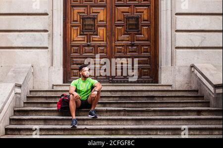 Young man sitting on stairs after workout Stock Photo