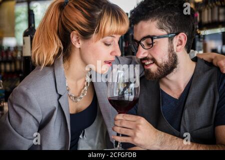 man and Woman smelling red wine in glass having degustation in market wine house. Stock Photo