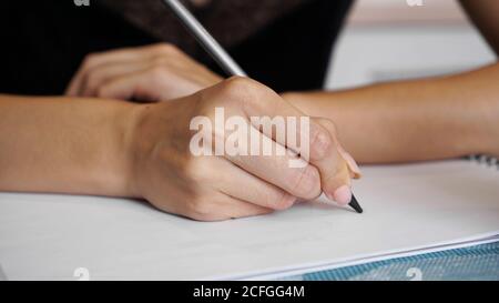 Woman hand use pencil writing on clear white sheet Stock Photo
