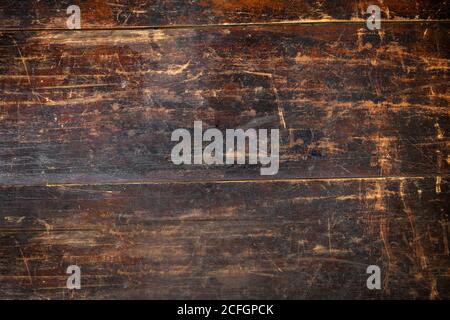 Full frame background texture of an old stained and scratched vintage brown wooden board with planks Stock Photo