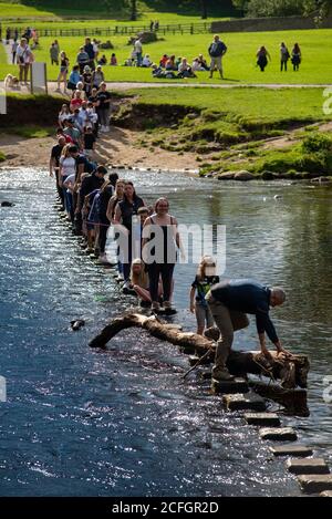 Crossing the stepping stones across the River Wharfe in the Yorkshire Dales, England, UK Stock Photo