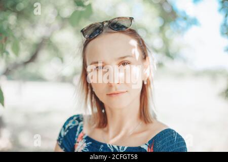 Portrait head shot of beautiful pensive Caucasian middle age woman with long light bob hair. Casual style real person in blue dress. Closeup face Stock Photo