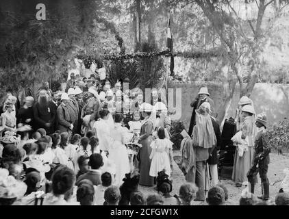 Original Caption:  State visit to Jerusalem of Wilhelm II of Germany in 1898. Empress receiving gifts from schoolgirls at garden reception.  - Location: Jerusalem ca.  1898 Stock Photo