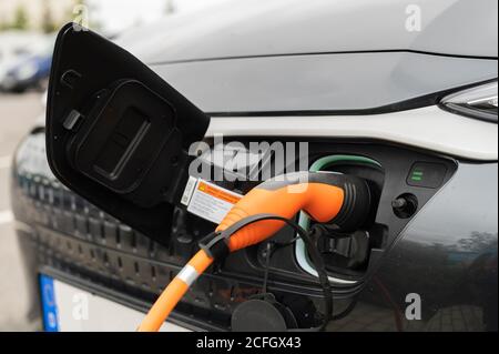 The plug of a charging cable is in an electric car Stock Photo