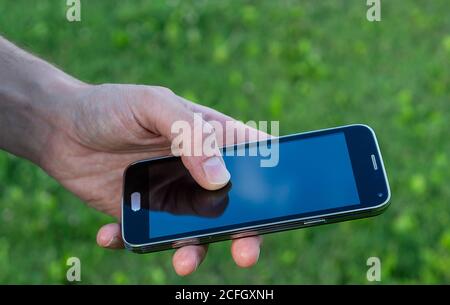 man hand holding mobile phone tap on screen Stock Photo