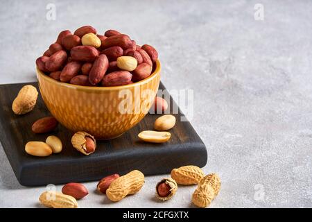 Roasted peeled peanuts in ceramic bowl  , closeup, copy space Stock Photo