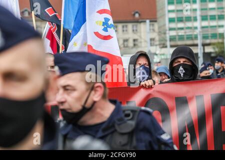 Gdansk, Poland. 5th Sep, 2020. The 'No more brother war' march participant with face covered with mask with white supremacist version of the Celtic Cross (or Odins Cross, Sun Cross, Wheel Cross) symbol used by the fascist and nationalist organizations is seen in Gdansk, Poland, on 5 September 2020 The march of the far-right, nationalist and racist organizations passed through the streets of the Gdansk city with a strong police escort. March participants chanted nationalist slogans as White Europe, White Life Matters, Scrap the Eu! etc. Credit: Vadim Pacajev/Alamy Live News Stock Photo