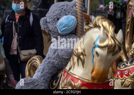 Moscow, Russia. 5th of September, 2020 A stuffed bear toy wearing a protective mask seats on a carousel horse in the Moscow city during the restrictions with the novel coronavirus COIVD-19 pandemic in Russia Stock Photo