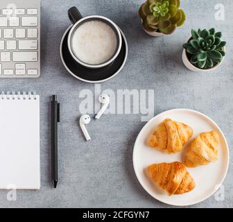 White Notepad, wireless headphones, coffee mug. The concept of online training, work from home, home office. Copy space. Stock Photo