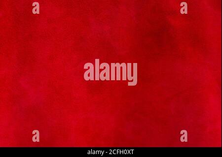 Red matte background of suede fabric, closeup. Velvet texture of seamless wine leather. Felt material macro. Stock Photo