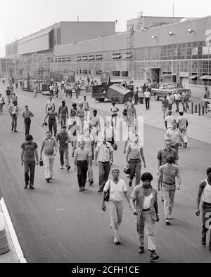 1970s MEN AND WOMEN ANONYMOUS LABOR FORCE LEAVING FACTORY BUILDING DURING SHIFT CHANGE AT AUTOMOTIVE PLANT NEWARK DELAWARE USA - i6311 HAR001 HARS FULL-LENGTH LADIES PERSONS UNITED STATES OF AMERICA MALES PROFESSION B&W NORTH AMERICA NORTH AMERICAN SKILL OCCUPATION SKILLS HIGH ANGLE AFRICAN-AMERICANS AFRICAN-AMERICAN AND CAREERS EXTERIOR WORKFORCE BLACK ETHNICITY LABOR AT IN OPPORTUNITY AUTOMOTIVE EMPLOYMENT OCCUPATIONS SHIFT CONNECTION NEWARK ESCAPE EMPLOYEE TOGETHERNESS BLACK AND WHITE CAUCASIAN ETHNICITY DURING HAR001 LABORING OLD FASHIONED AFRICAN AMERICANS Stock Photo