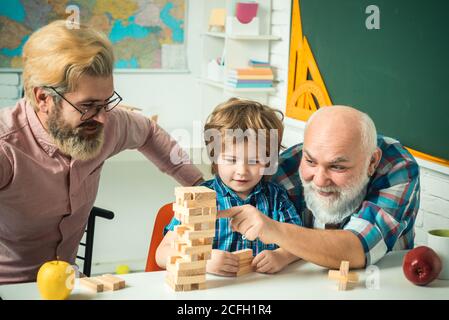 Male generations friendship. Happy little child father and grandparent leisure fun time. Grangfather, Father and son playing game at home. Stock Photo