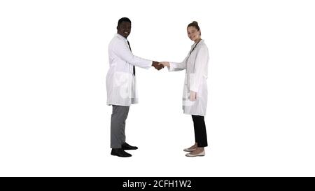 Doctors shaking hands and posing to camera on white background. Stock Photo