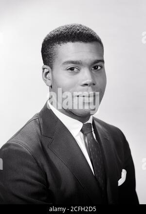 1950s 1960s PORTRAIT OF AFRICAN-AMERICAN MAN WEARING SUIT AND TIE LOOKING AT CAMERA  - n277 HAR001 HARS LIFESTYLE JOBS STUDIO SHOT HEALTHINESS COPY SPACE PERSONS MALES PROFESSION EXPRESSIONS B&W EYE CONTACT SKILL OCCUPATION SELLING HAPPINESS SKILLS WELLNESS HEAD AND SHOULDERS CHEERFUL STRENGTH AFRICAN-AMERICANS AFRICAN-AMERICAN AND CAREERS CHOICE LEADERSHIP BLACK ETHNICITY PRIDE OPPORTUNITY AUTHORITY OCCUPATIONS SMILES CONNECTION JOYFUL STYLISH PANORAMIC COMPETENT EAGER GROWTH SALESMEN YOUNG ADULT MAN BLACK AND WHITE HAR001 OLD FASHIONED AFRICAN AMERICANS Stock Photo
