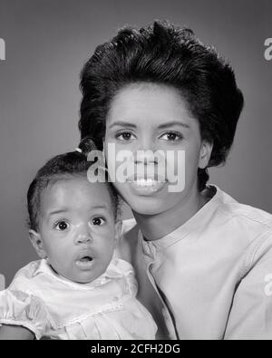 1960s PORTRAIT SMILING AFRICAN-AMERICAN MOTHER HOLDING BABY GIRL DAUGHTER WITH SURPRISED FACIAL EXPRESSION LOOKING AT CAMERA - n2093 HAR001 HARS SURPRISE NOSTALGIA OLD FASHION 1 JUVENILE FACIAL PLEASED FAMILIES JOY FEMALES HEALTHINESS LADIES DAUGHTERS PERSONS CONFIDENCE EXPRESSIONS I B&W BUG-EYED HAPPINESS CHEERFUL AFRICAN-AMERICANS AFRICAN-AMERICAN BLACK ETHNICITY PRIDE SMILES CONNECTION JOYFUL WIDE-EYED GROWTH JUVENILES MOMS STARTLED TOGETHERNESS BLACK AND WHITE HAR001 OLD FASHIONED AFRICAN AMERICANS Stock Photo