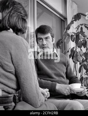 1970s MAN HUSBAND WITH SERIOUS STERN FACIAL EXPRESSION SITTING HOLDING CUP OF COFFEE LOOKING AT WOMAN WIFE SITTING BESIDE HIM - s20813 HAR001 HARS FACIAL ANGER COMMUNICATION WORRY LIFESTYLE FEMALES MARRIED MOODY SPOUSE HUSBANDS HOME LIFE COPY SPACE HALF-LENGTH LADIES PERSONS CARING MALES EXPRESSIONS TROUBLED B&W CONCERNED PARTNER SADNESS CONFRONTATION DISAGREEMENT STERN AT OF AUTHORITY FEELING MOOD CONCEPTUAL GLUM BESIDE DOMINATING EMOTION EMOTIONAL EMOTIONS HIM MID-ADULT MID-ADULT MAN MID-ADULT WOMAN MISERABLE SEXIST WIVES BLACK AND WHITE CAUCASIAN ETHNICITY HAR001 OLD FASHIONED Stock Photo