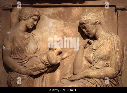 Ancient Greek bas-relief on grave stele, marble sculpture of women and child, funeral scene carved in stone in cemetery. Traditional monument of class Stock Photo