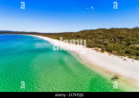 Stripe of white sandy beach with emerald water of Jervis bay - aerial overhead view of Australian pacific coast.