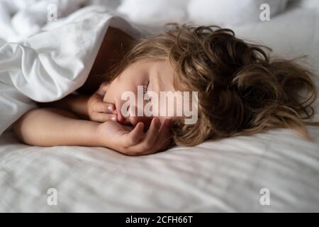 Adorable small kids rest asleep enjoy good healthy peaceful sleep or nap. Six years old Kid sleeping in bed. Stock Photo