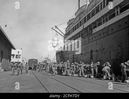 Middle East History - Palestine disturbances 1936. General view of the troops on the Haifa quay after disembarking from the Laurentic which looms up in the picture on the right Stock Photo