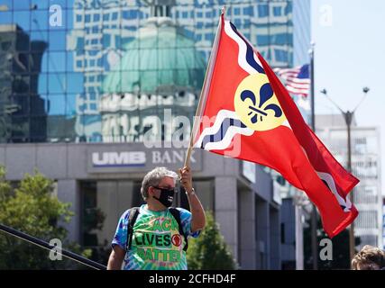 St. Louis, United States. 05th Sep, 2020. An attendee at the Rally Against Violence and Hatred, waves a St. Louis City flag, with a reflection of the Old Courthouse in St. Louis on Saturday, September 5, 2020. Photo by Bill Greenblatt/UPI Credit: UPI/Alamy Live News Stock Photo