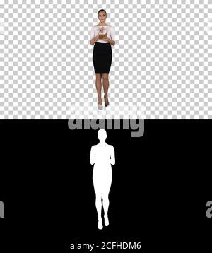 Young woman making notes while walking, Alpha Channel Stock Photo