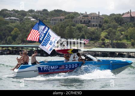 Lakeway, Texas USA Sept. 5, 2020: Boater flying flags supporting U.S. President Donald Trump participates in a pro-Trump boat parade that attracted hundreds of watercraft of all sizes. Several boats were swamped or sunk by the huge waves kicked up by the flotilla's wakes but no injuries were reported. Credit: Bob Daemmrich/Alamy Live News Stock Photo