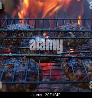 Beef steaks on the grill with flames and smoke Stock Photo