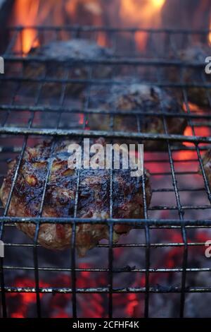 Beef steaks on the grill with flames and smoke Stock Photo