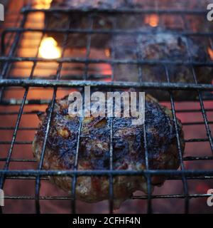 Beef steaks on the grill with flames and smoke Stock Photo
