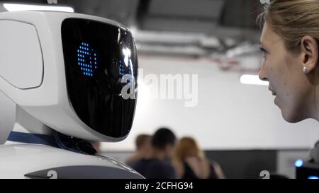 Girl is interacting with the humanoid robot. Stock Photo