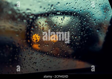 Blurred rain drop on the car glass background, water drops at the car window driver side. Stock Photo
