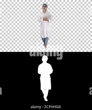 Woman doctor walking holding tablet, Alpha Channel Stock Photo