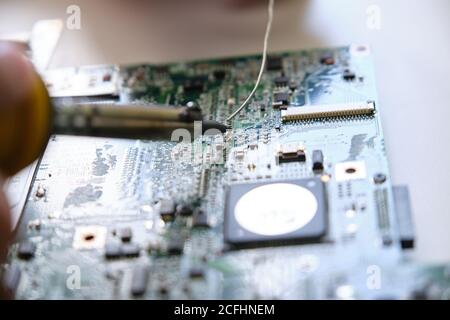Repairing a printed circuit board with a soldering iron. Technology concept. Stock Photo
