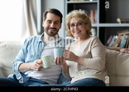 Head shot portrait smiling man with mature mother drinking tea Stock Photo