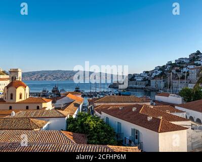 Early morning view of Hydra Island port. The Sun was low on the horizon, so the east part of the town is still in the shadow whilst the west was sunny Stock Photo