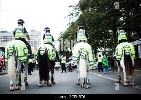 Officers on police horses gather in front of protesters Stock Photo