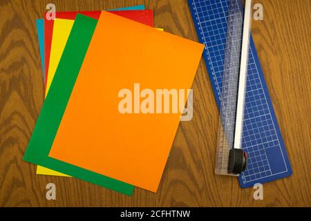 paper cutter and color origami paper on the wooden table Stock Photo