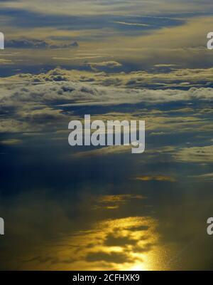 Awesome evening heaven clouds over golden sunset sea landscape. Stock Photo