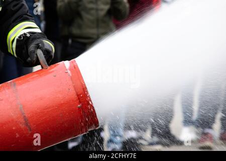 Supply of foam from the foam generator, fire extinguishing foam flies from the foam generator, which keeps the fireman in combat clothing Stock Photo
