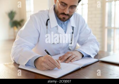 Close up focused doctor wearing uniform working with documents Stock Photo