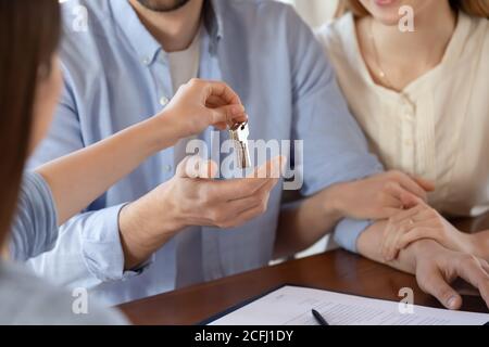 Close up young married couple receiving keys from new house Stock Photo