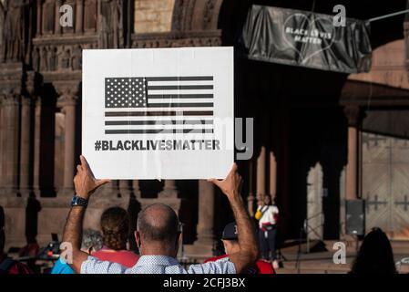 Boston, USA. 05th Sep, 2020. Rally for Black Lives, Black Voices & Jacob Blake.  Boston, MA, USA. Copley Square.  More than 500 gathered in Copley Square, in front of Trinity Church in central Boston on Sept. 5th  2020 in support of Black Lives Matter. Photo shows a man holding a BLM sign with Trinity Church in the background. Credit: Chuck Nacke/Alamy Live News Stock Photo