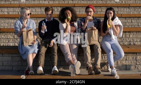 Students having lunch break outside the university. Stock Photo